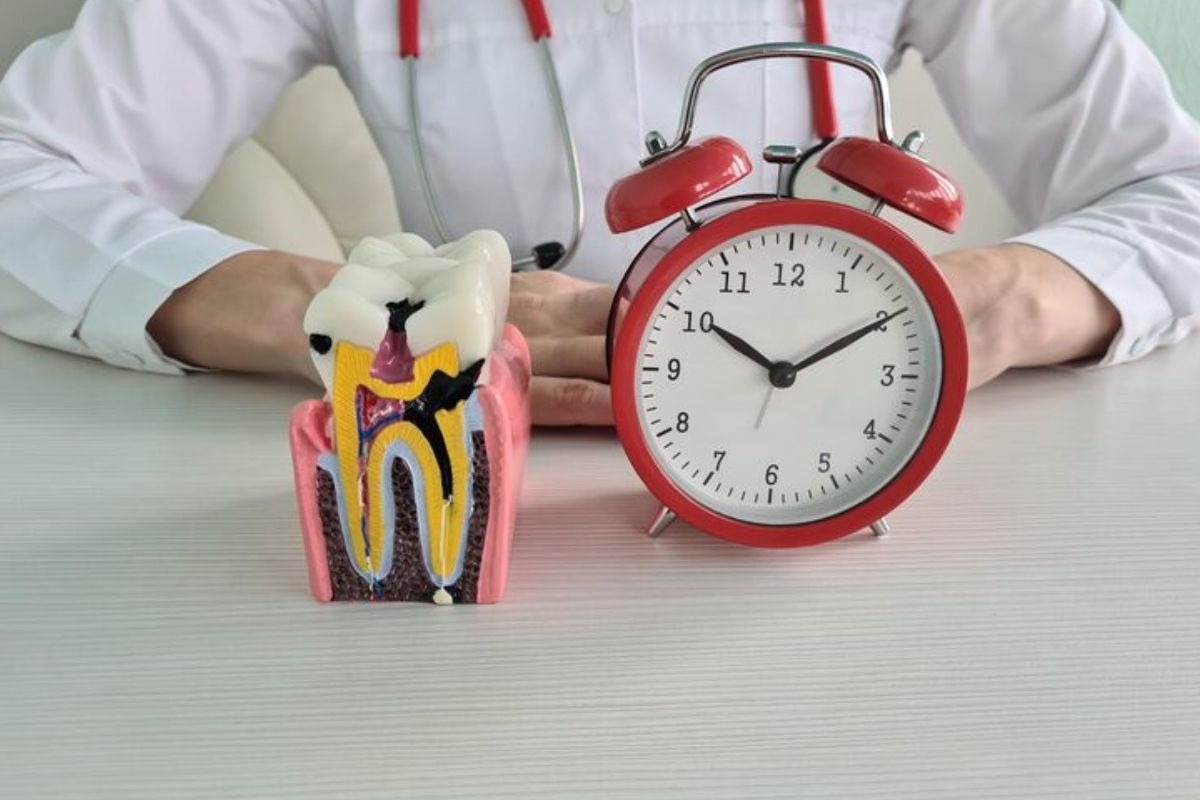 dentist examining a tooth filling with a clock to illustrate factors that can cause fillings to fail over time.